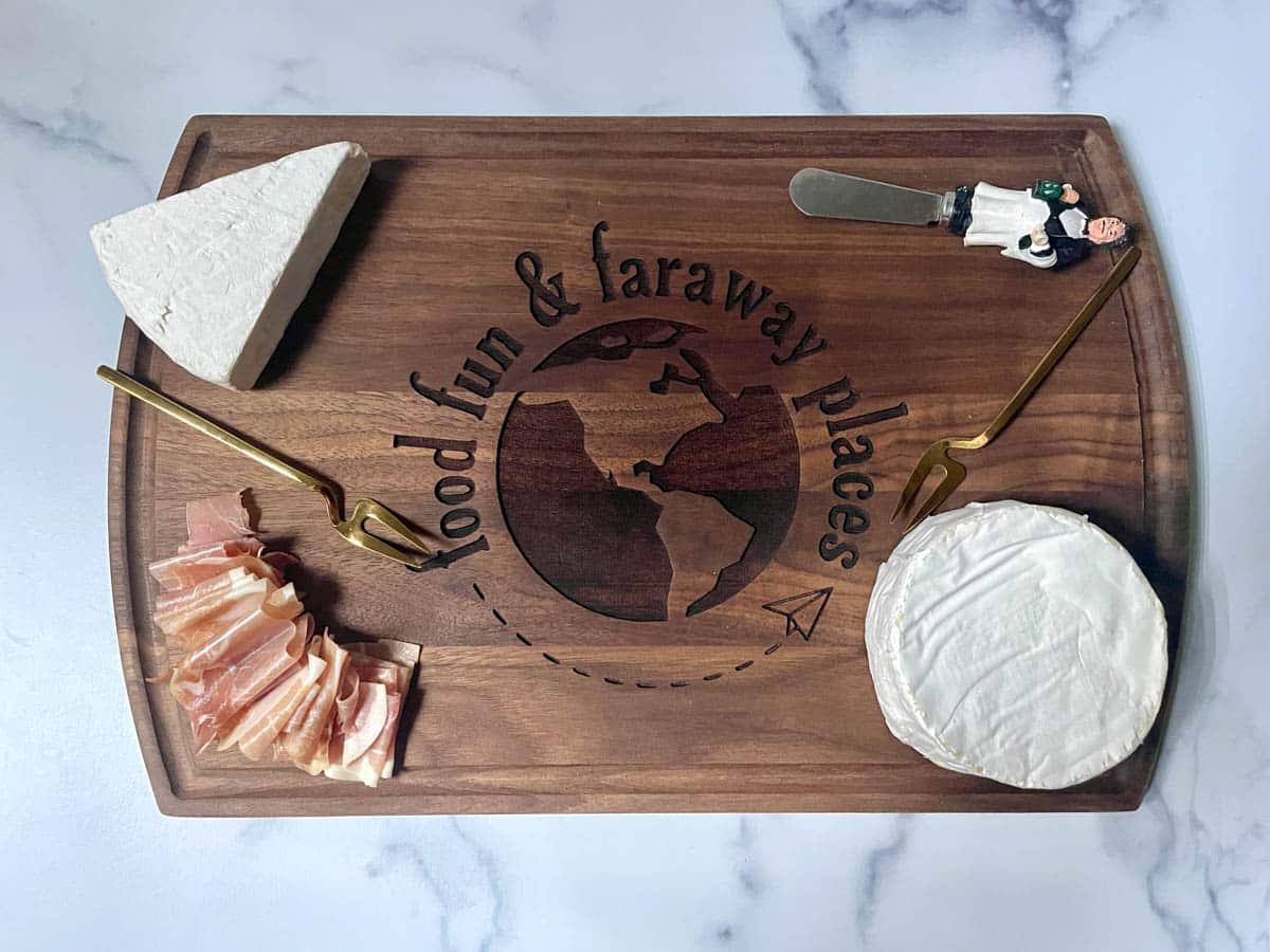 Brie and prosciutto on a cutting board.