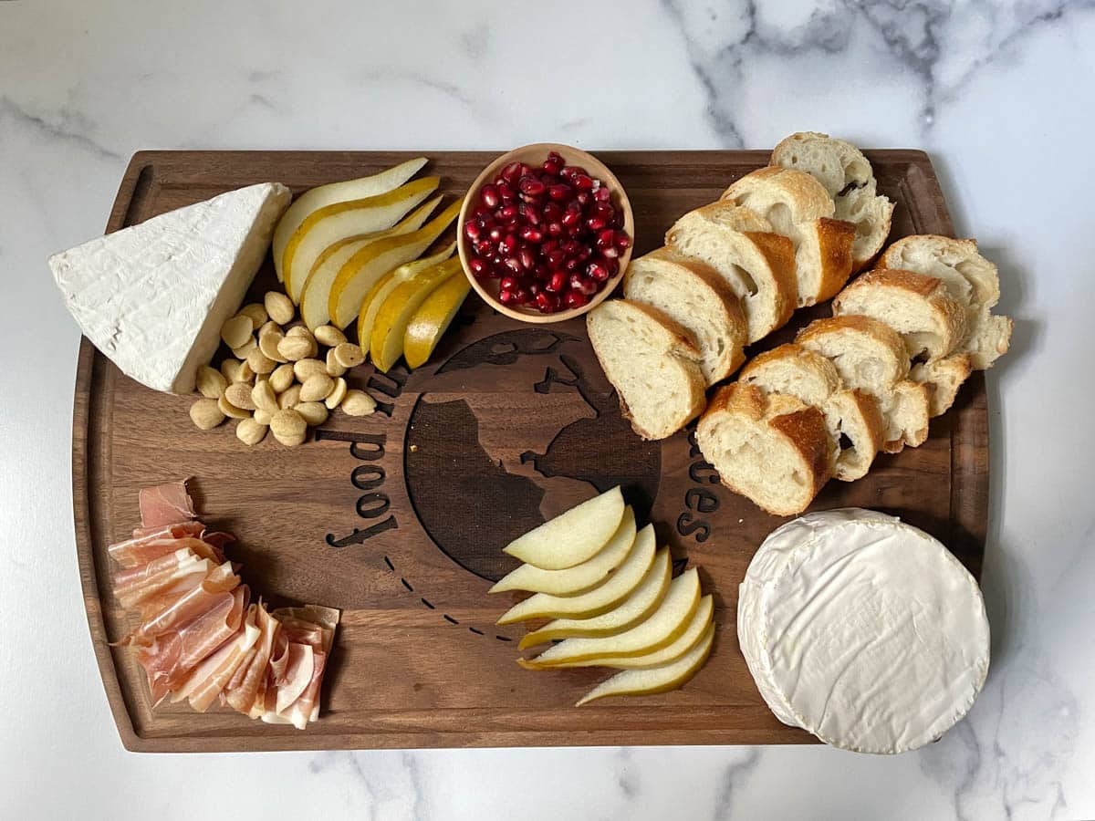 Brie charcuterie board with fruit, nuts, and bread.