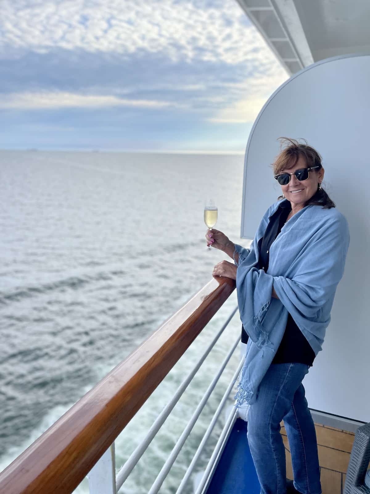 Woman on cruise ship with glass of champagne.