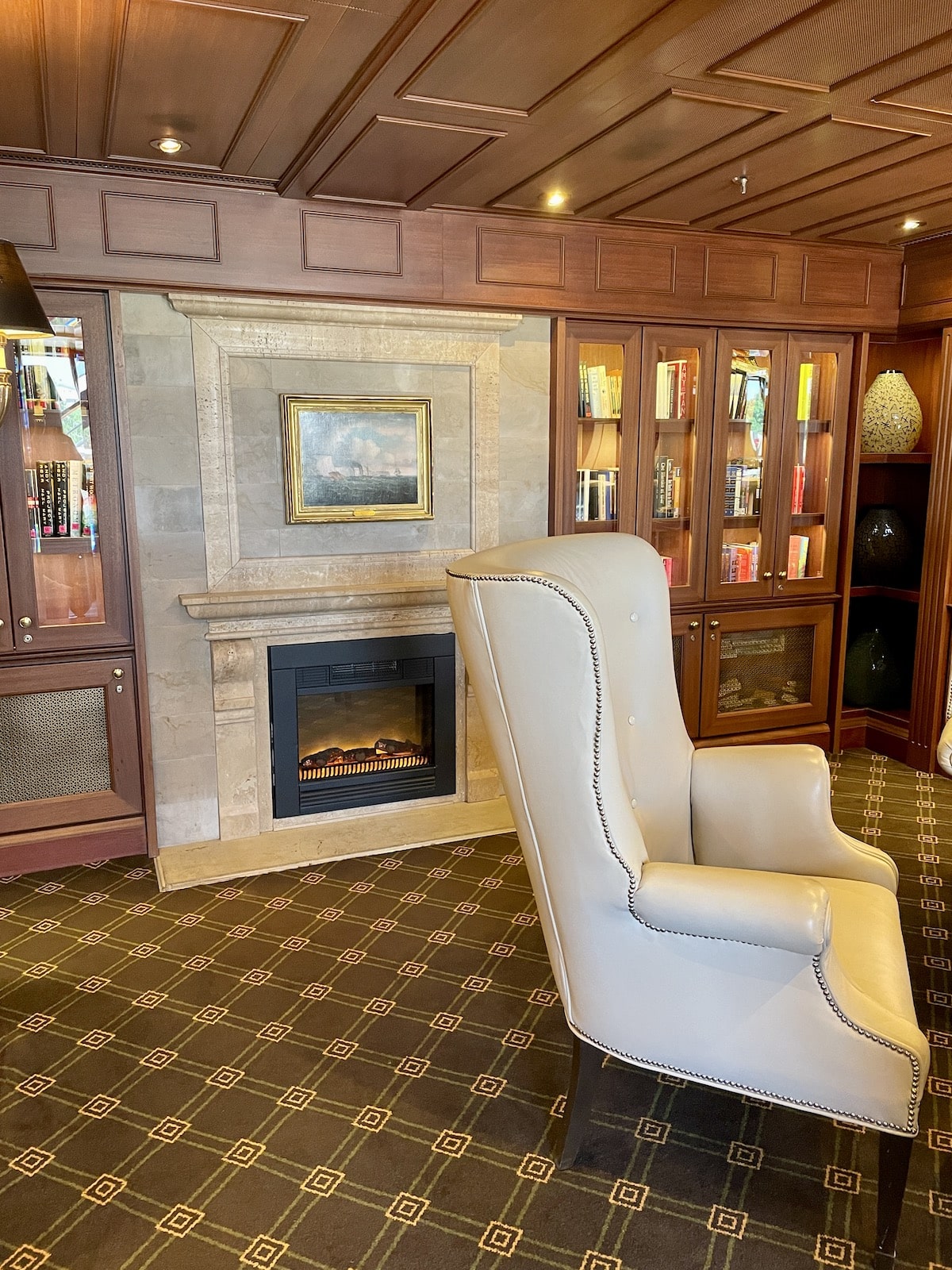 Library with chair and fireplace.