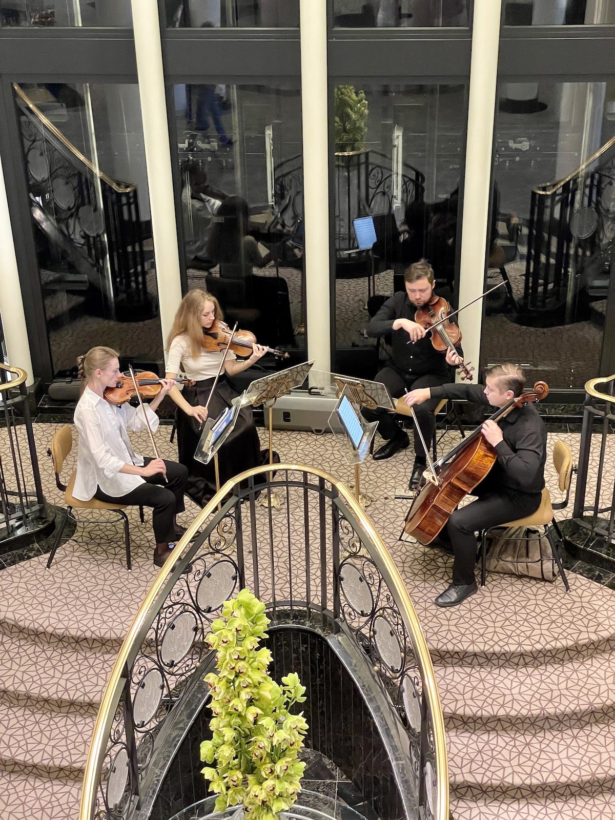 Four people with musical instruments playing on a cruise ship.