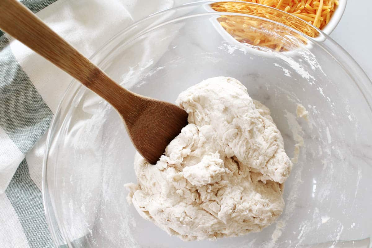 Flour, salt, and yeast with water in a glass bowl.