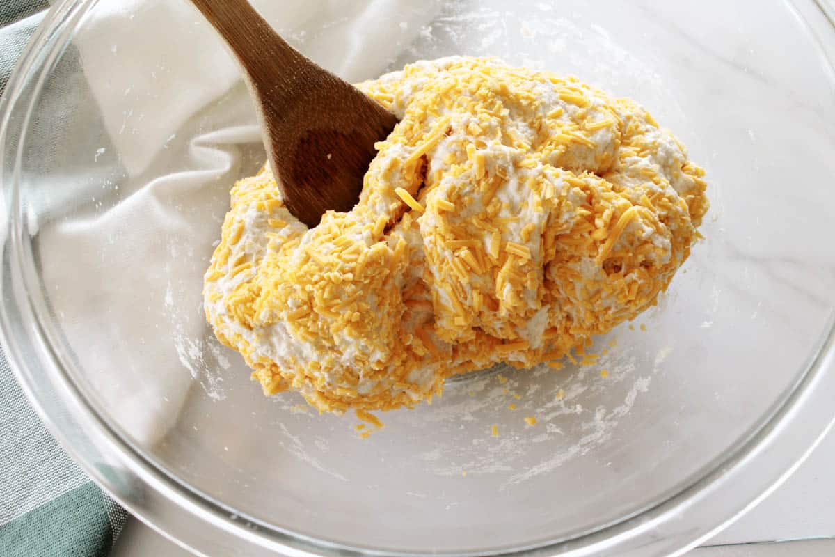Flour, salt, yeast, and cheddar in a glass bowl.