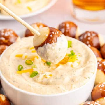 German beer cheese in a white bowl surrounded by pretzel bites.
