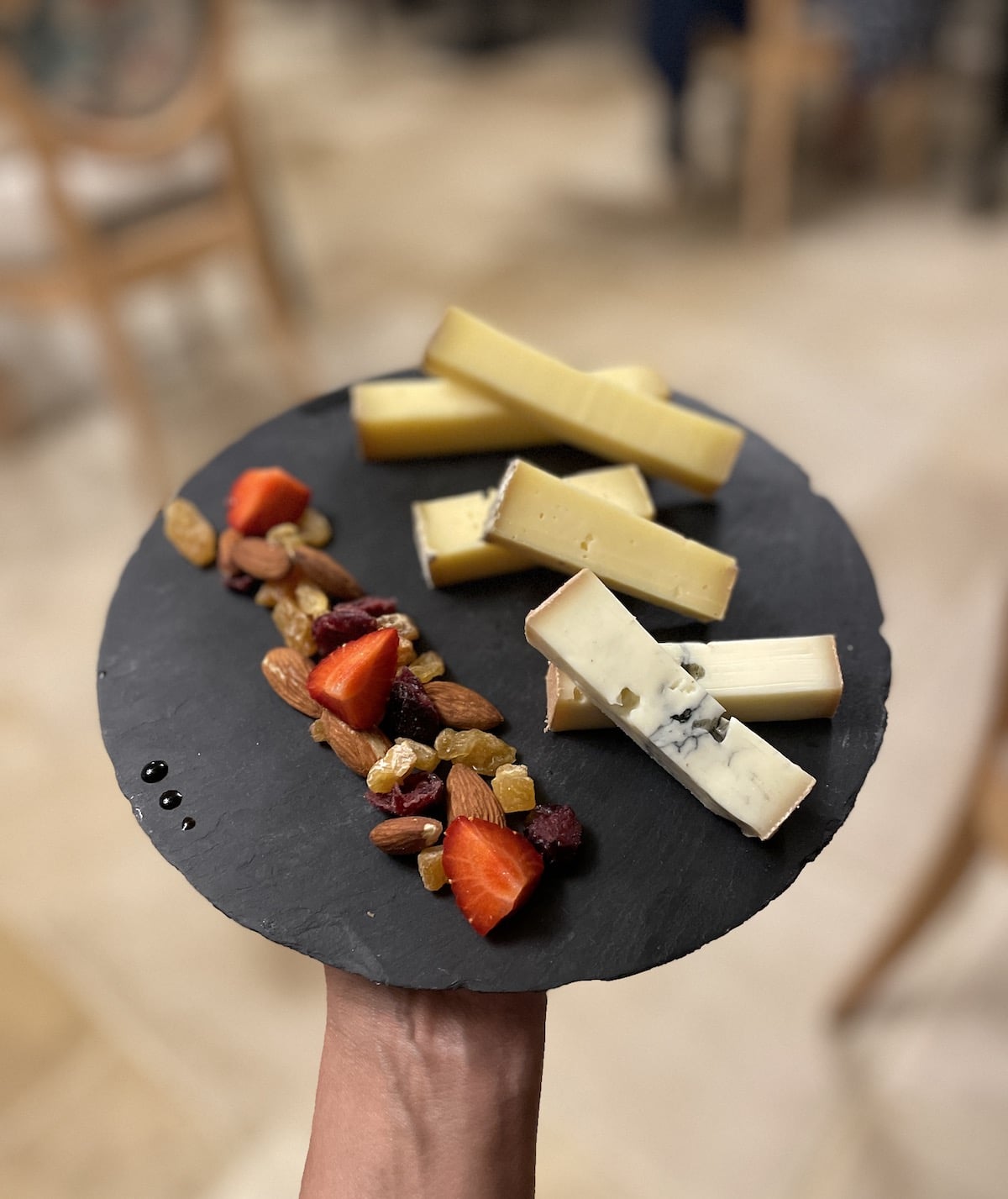 Comte cheese platter on a black stone circle.