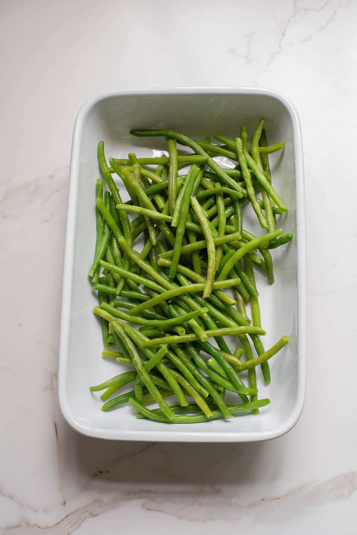 Green beans in white baking dish.