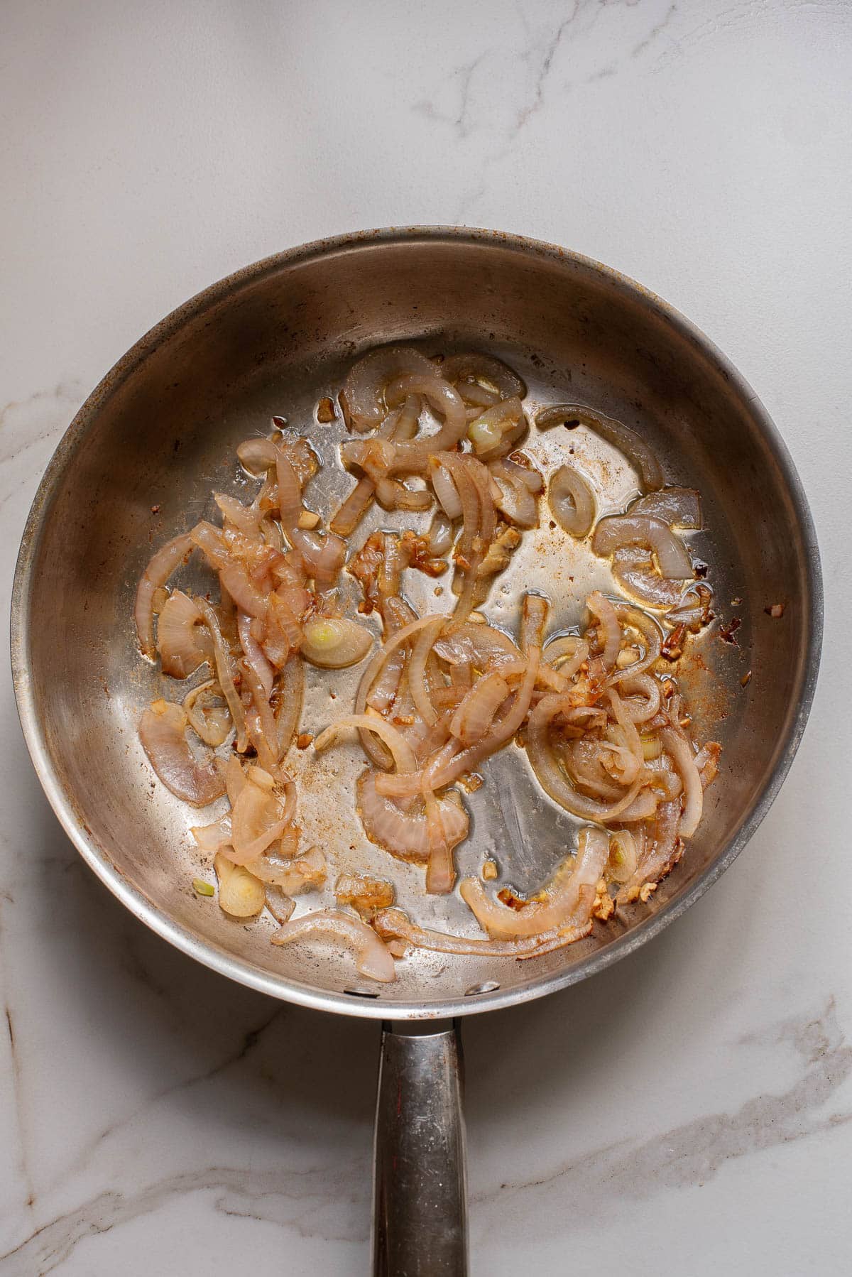 Onions sizzling in pan.