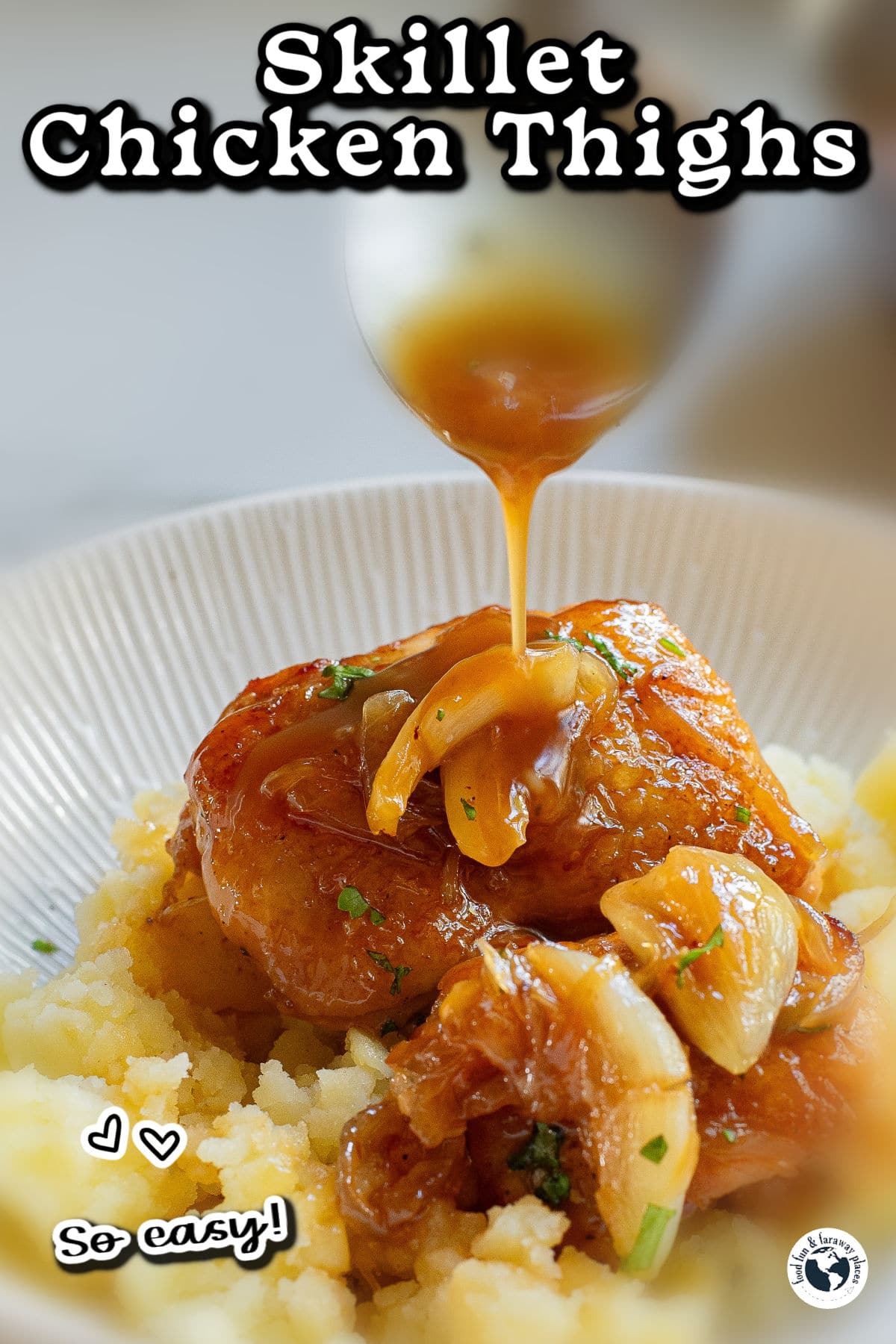 Chicken thighs over mashed potatoes with spoon dripping gravy over dish.