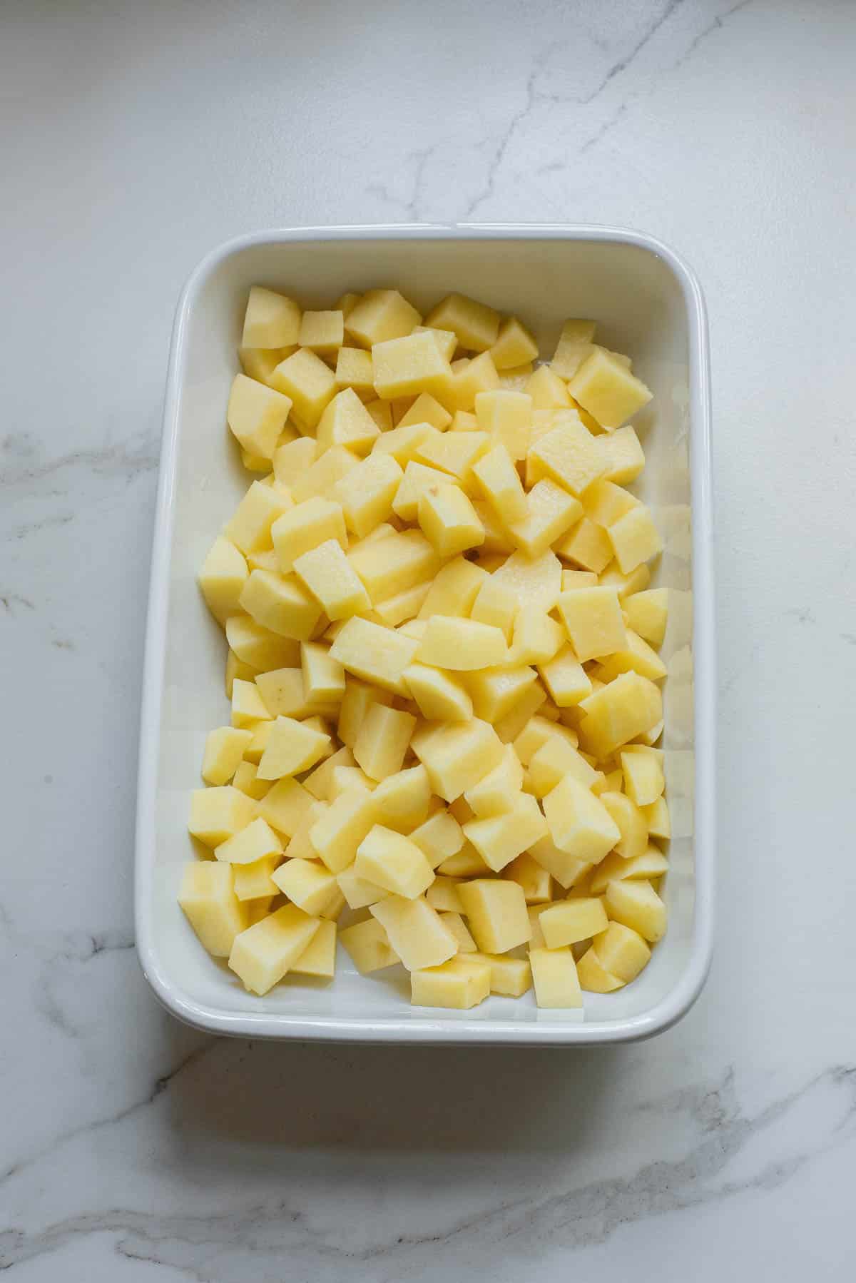 Potatoes in a white casserole dish.