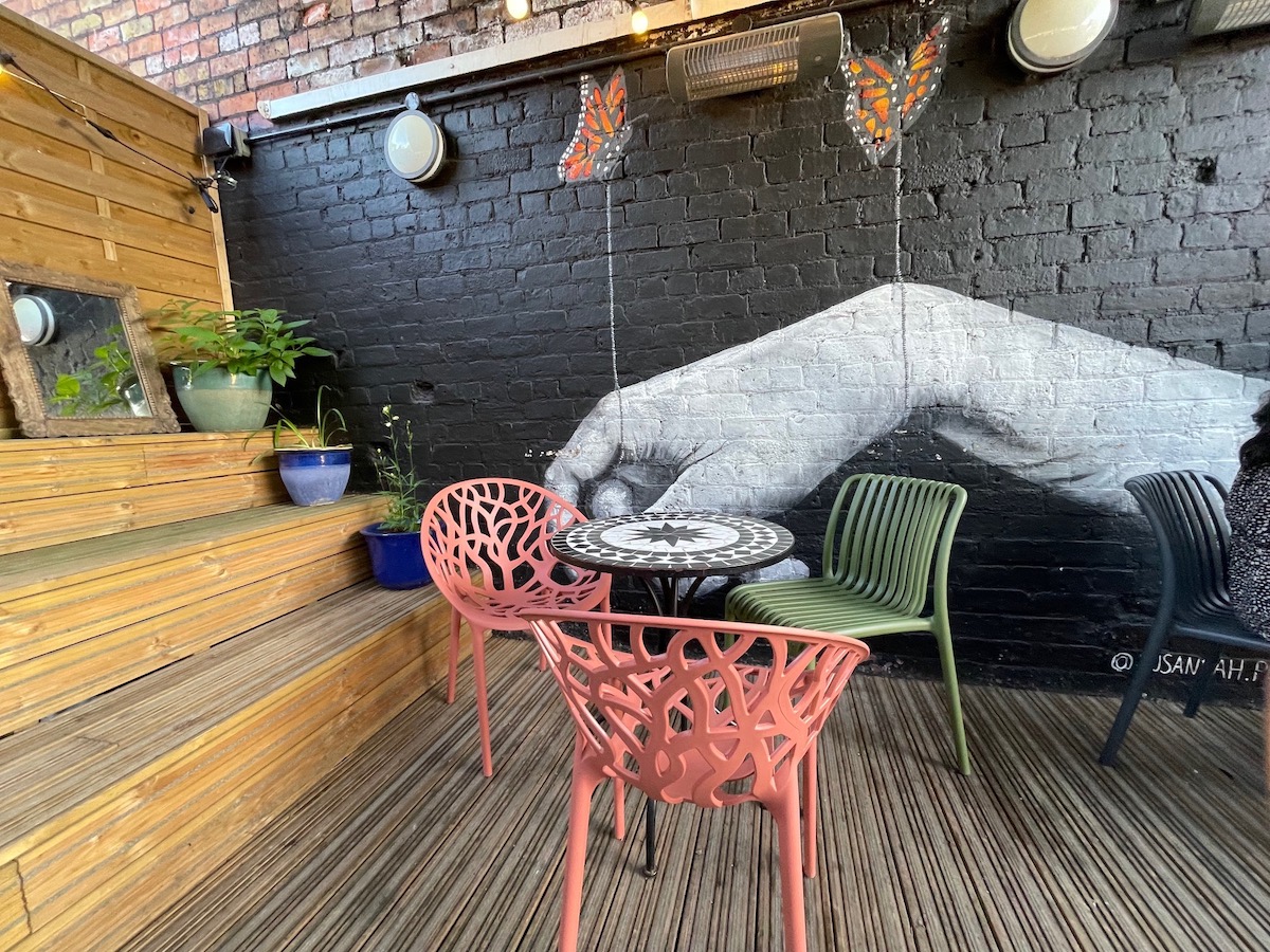 Restaurant patio with street art in background.