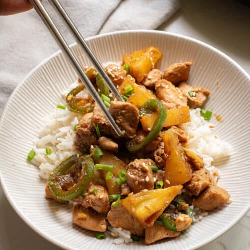 Chicken, pineapple, and jalapenos over white rice in white bowl.