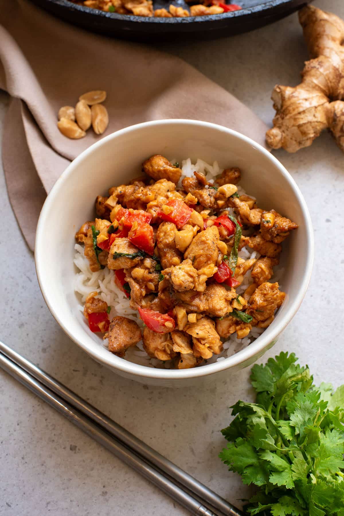 Chicken stir fry in a white bowl with rice.