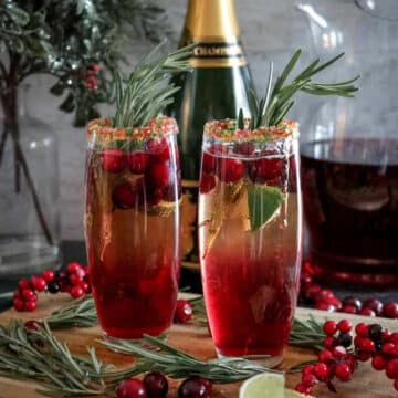Cranberry and champagne in tall glasses with cranberries and Christmas greens.
