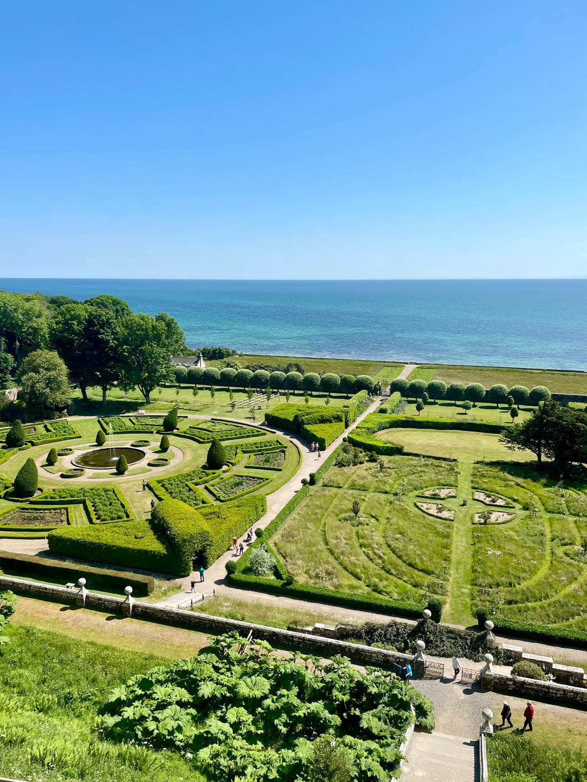 Manicured gardens with the sea in the background.