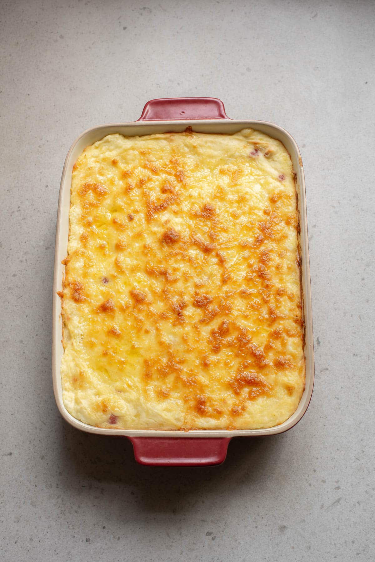 Golden brown mashed potatoes and cheese in a baking dish.