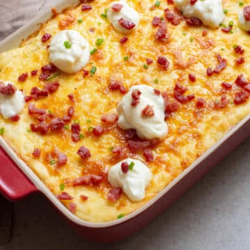 Potato casserole with bacon, cheese, and sour cream on top.