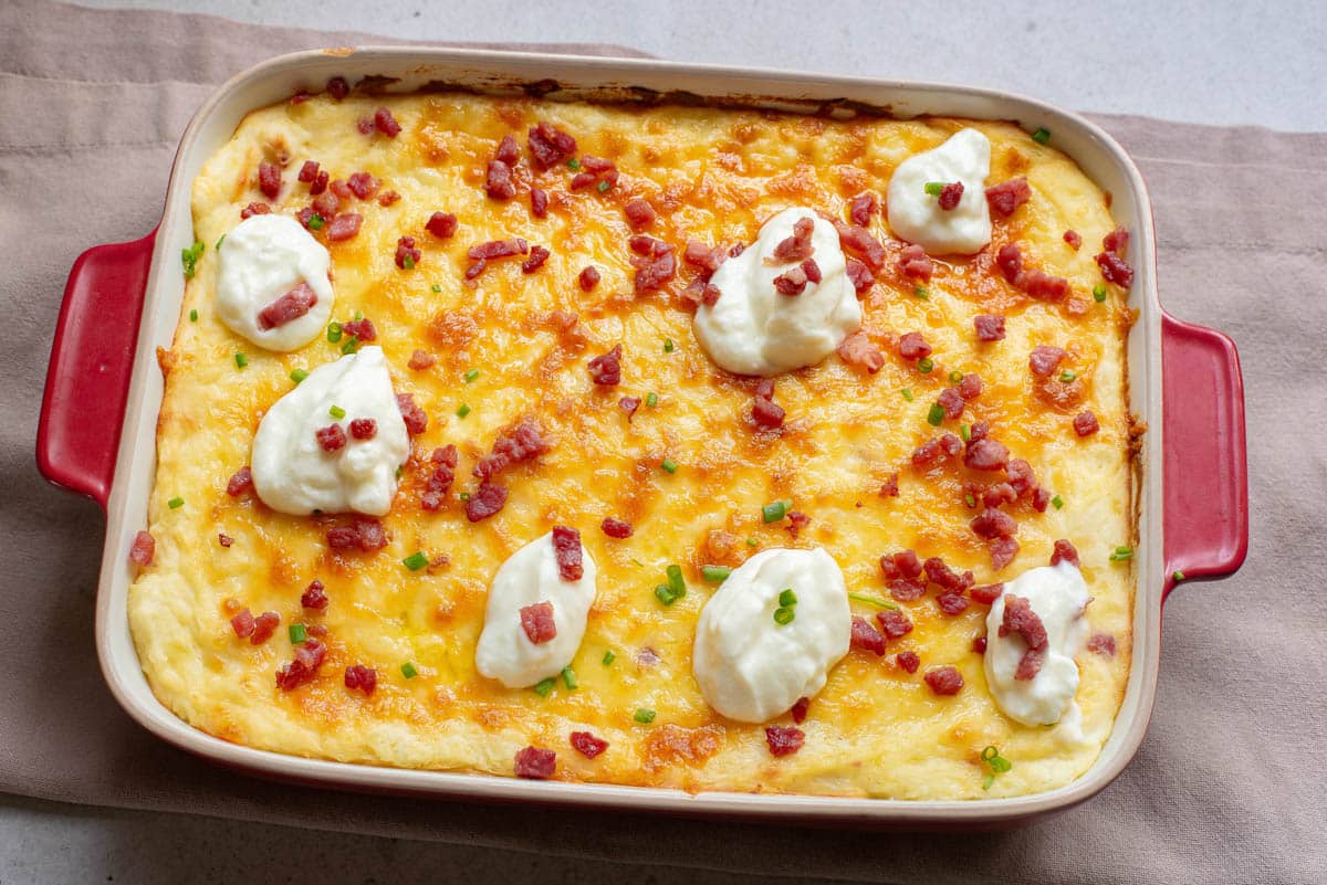 Potato casserole with bacon, cheese, and sour cream on top.