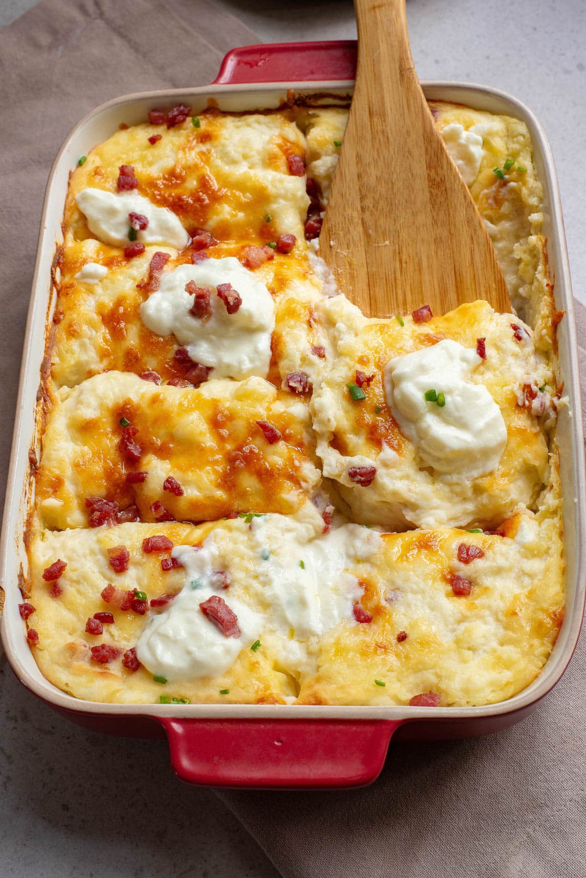 Potato casserole with bacon, cheese, and sour cream on top.