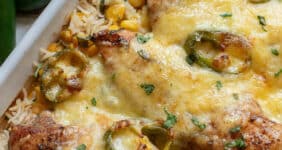 Chicken and rice with cheese and jalapenos in a casserole dish.