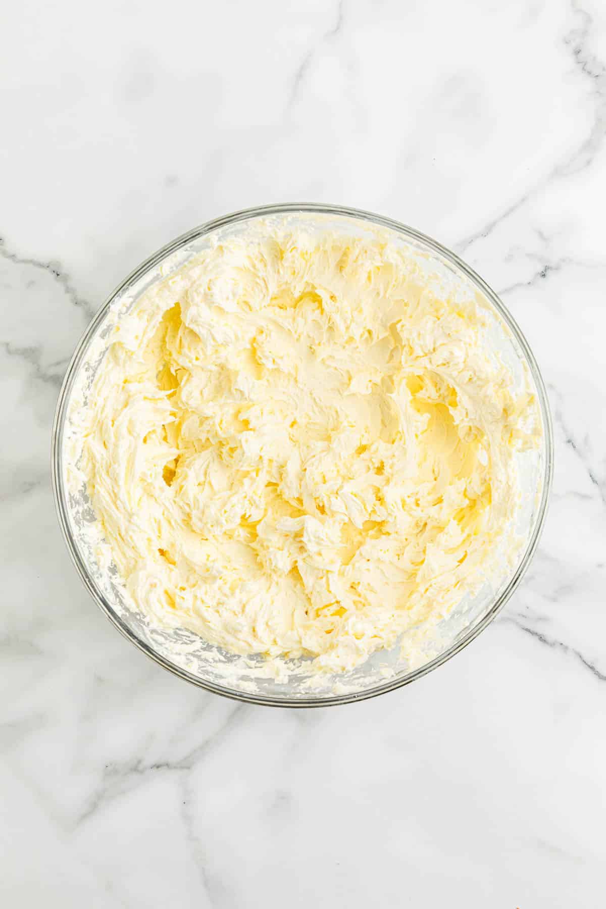 Whipped cream cheese in a glass bowl.