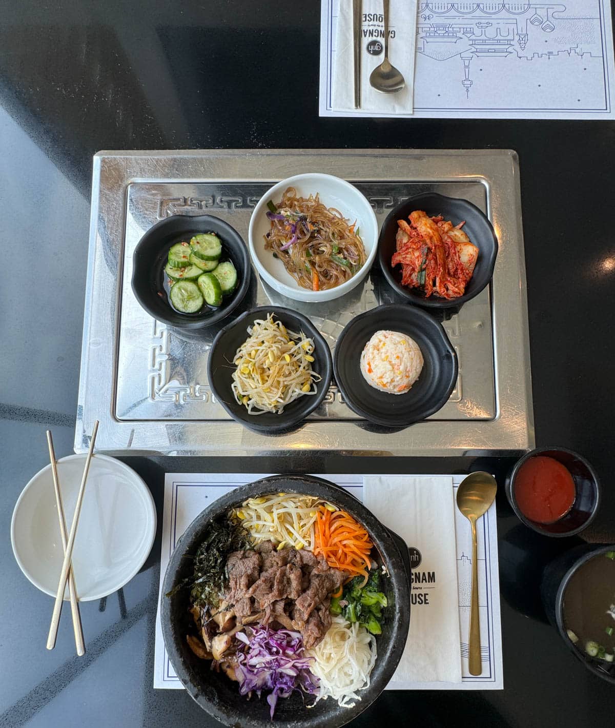 Korean meal with sides on black table in  Buena Park restaurant.