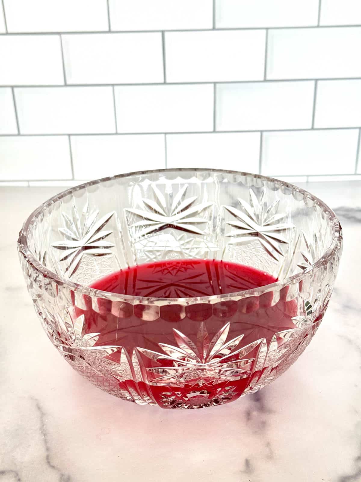 Cranberry and orange juice in glass punch bowl.