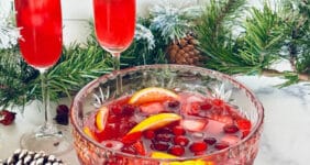 Glass bowl of punch with fruit with Christmas deocr.