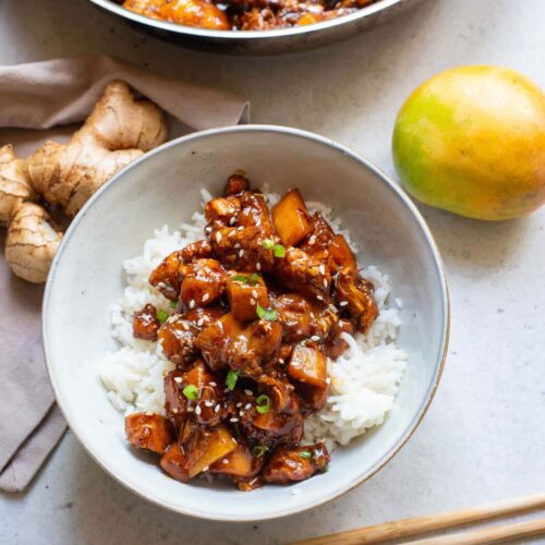 Chinese bourbon chicken in a white bowl over rice.