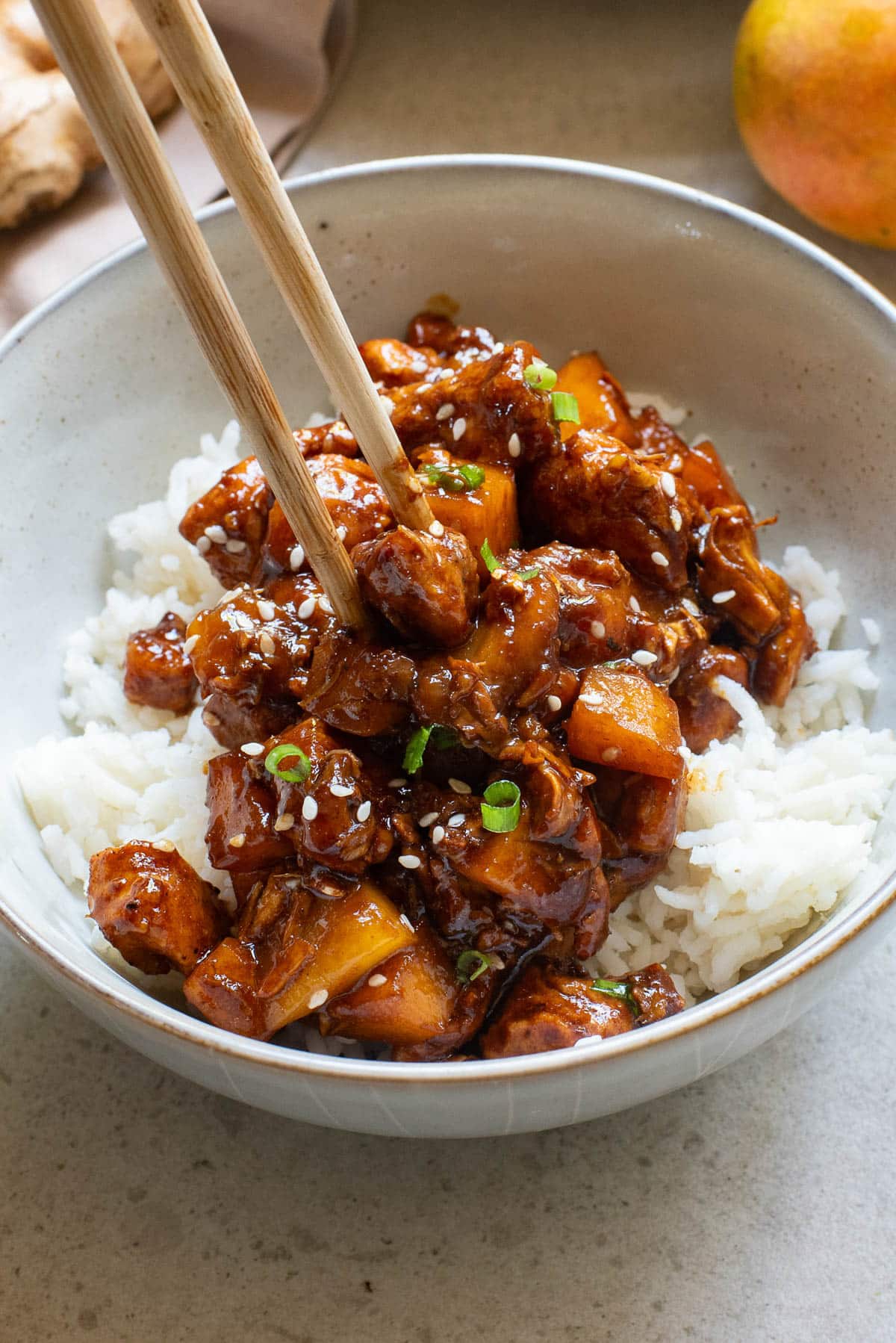 Chinese bourbon chicken in a white bowl over rice.