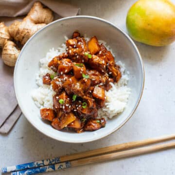 Chinese Bourbon chicken with white rice in a white bowl.