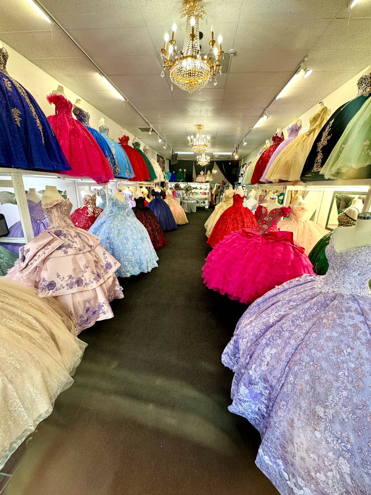 Colorful formal dresses long walls of store.