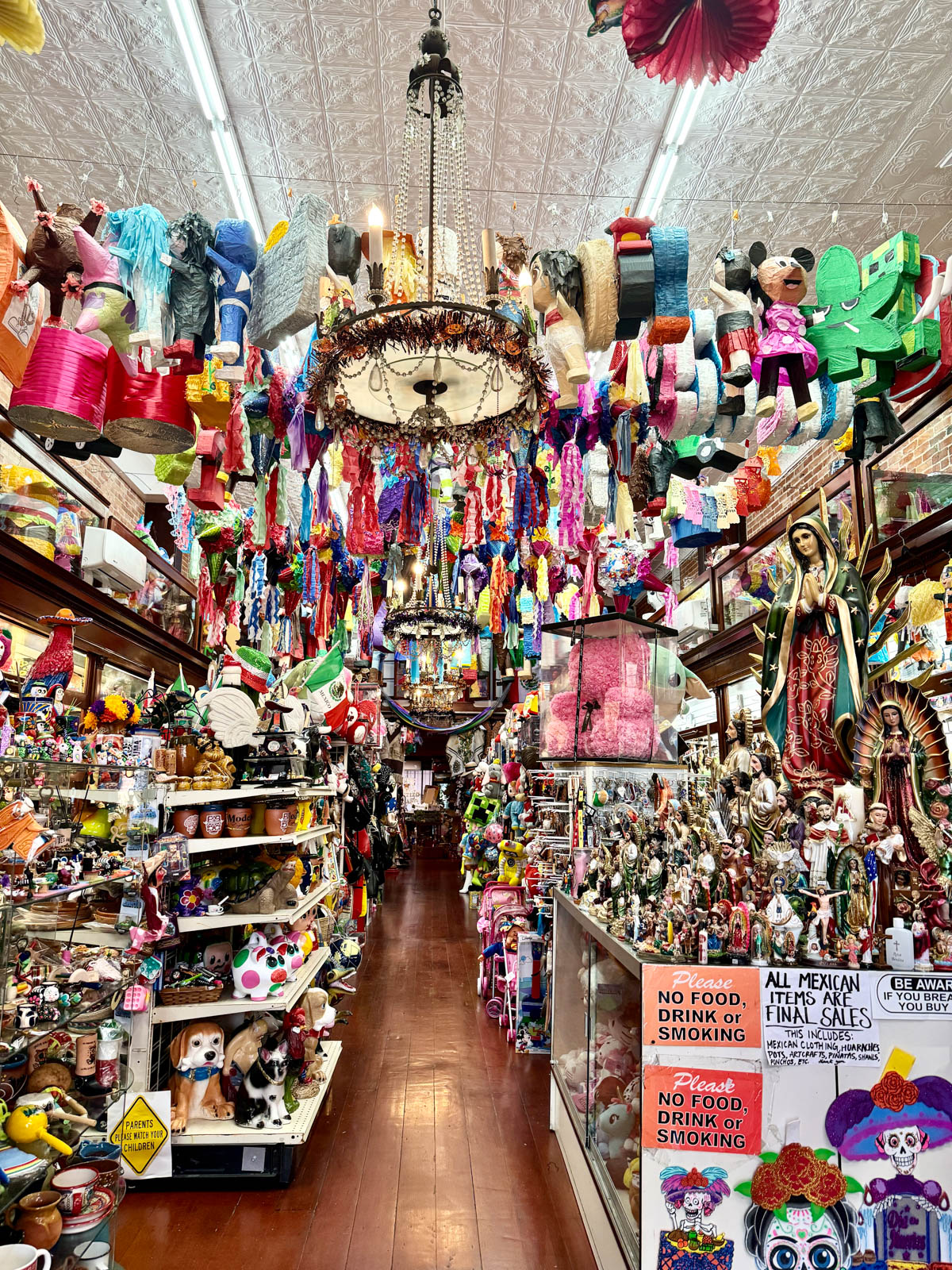 Inside of a store with full shelves and items hanging from ceiling.