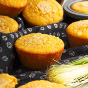 Cornbread muffins on black napkin with cornhusk.