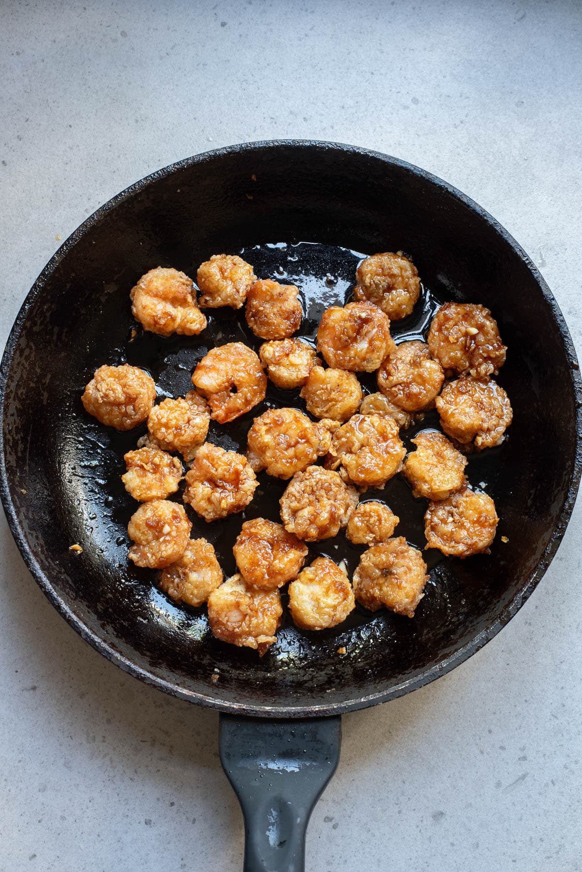 Fried shrimp with sauce in cast iron pan.