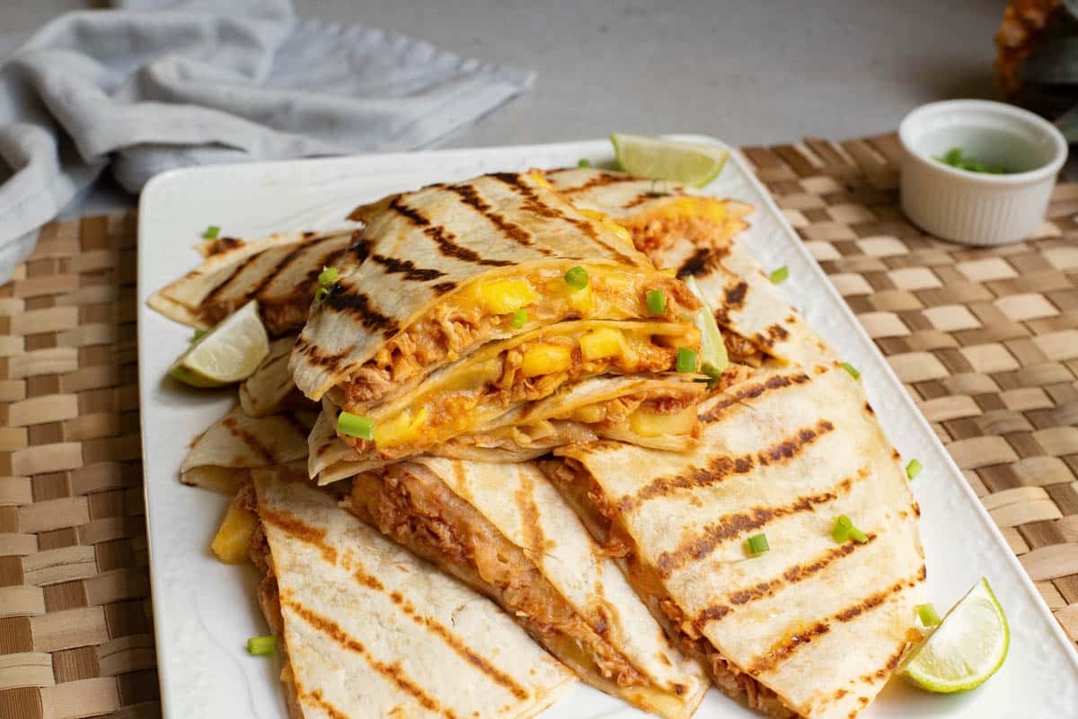 Quesadillas with cheese and chicken stacked on a plate.