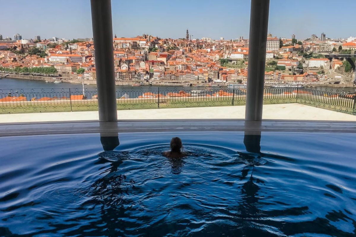 Person in swimming pool looking over old city.