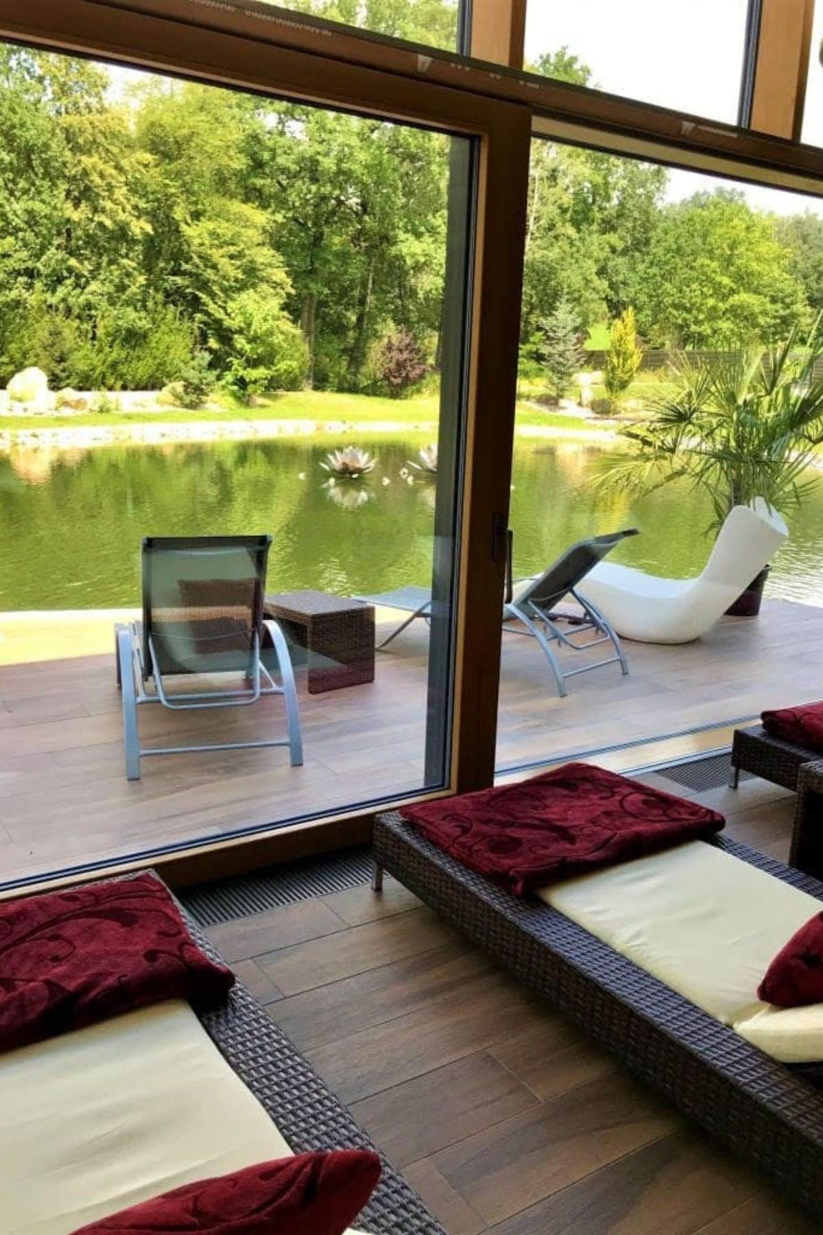 Lounge chairs through window overlooking lake.