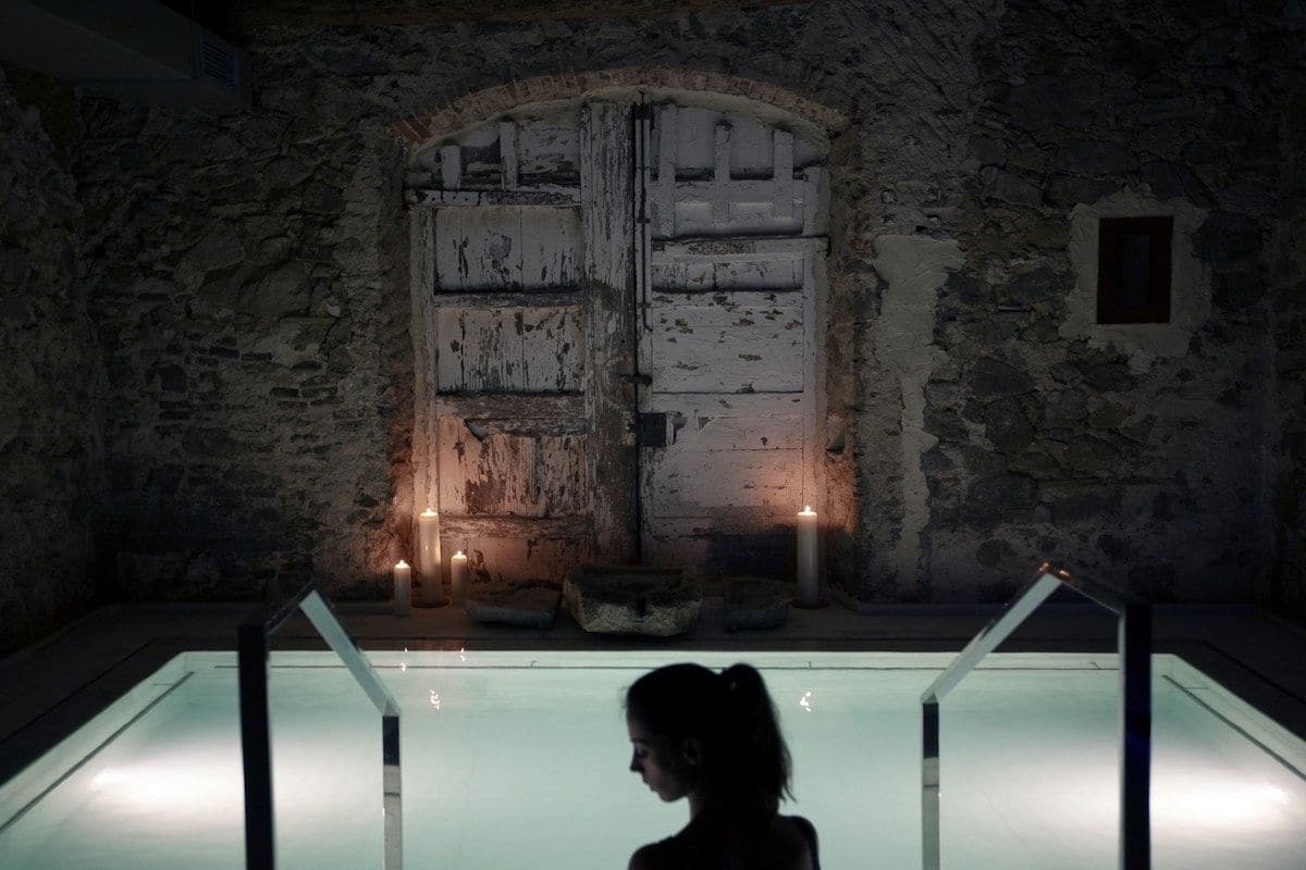 Woman in pool in darkened room.