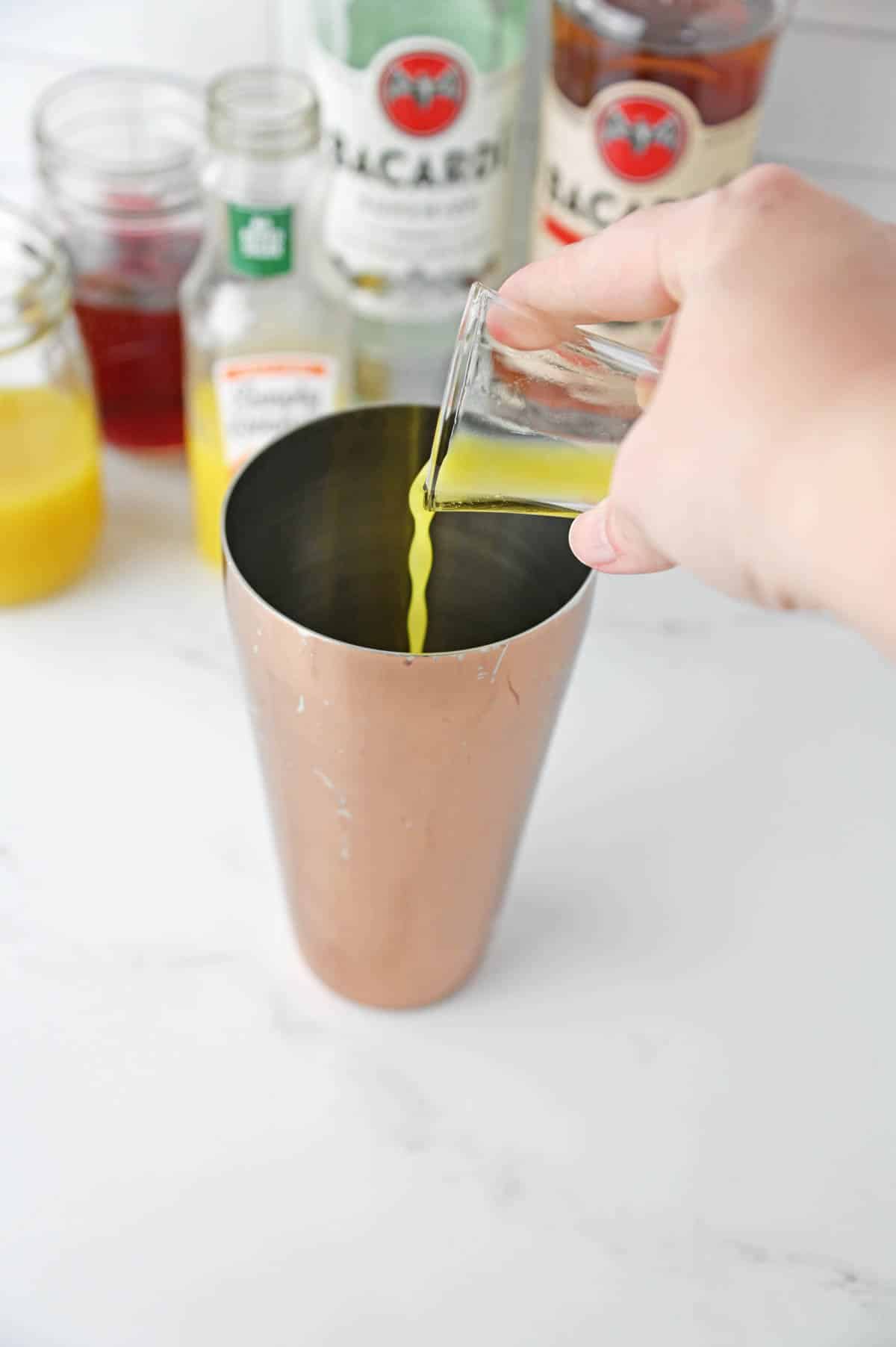 Pouring juice into a shaker cup.