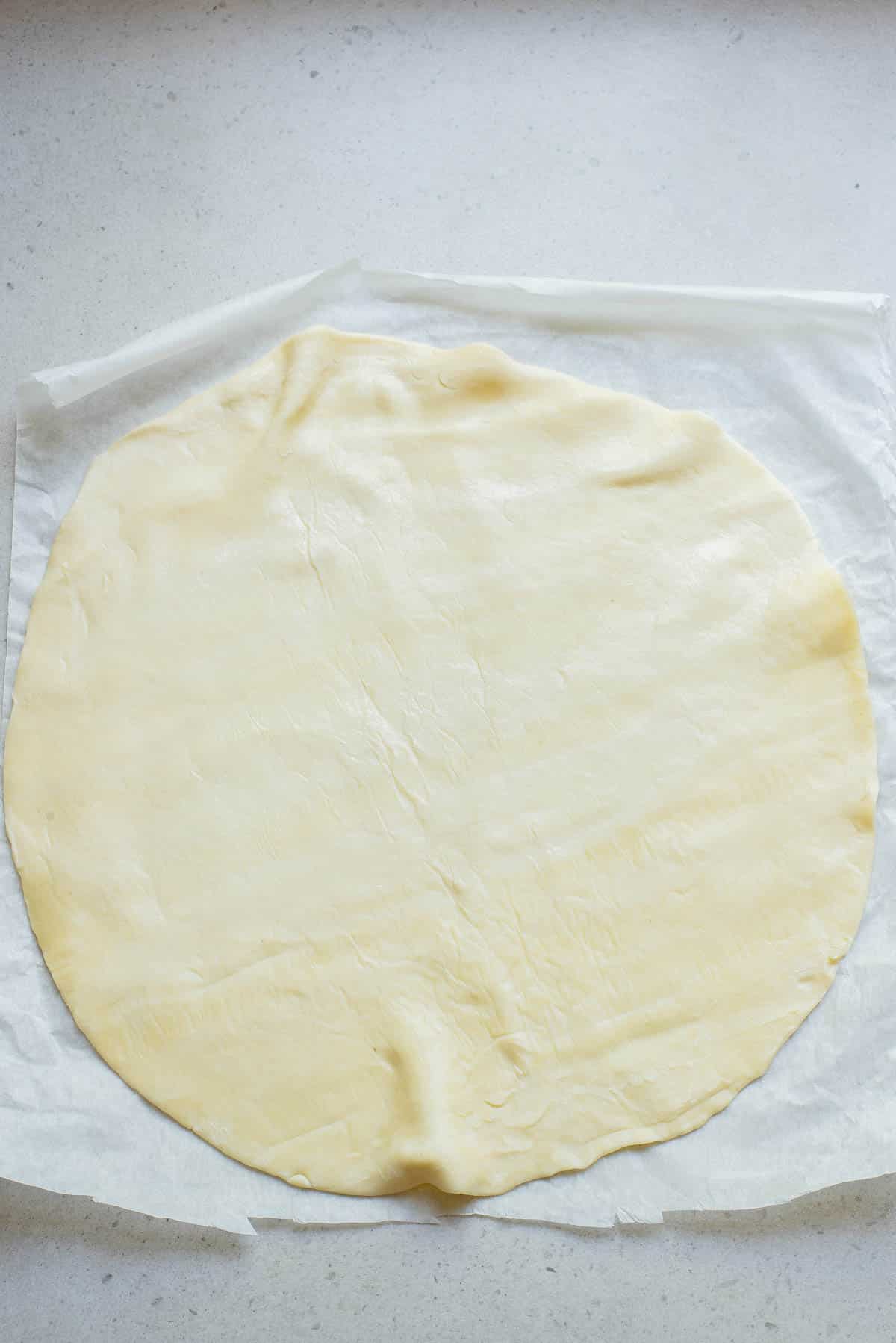 Pie crust on parchment paper.
