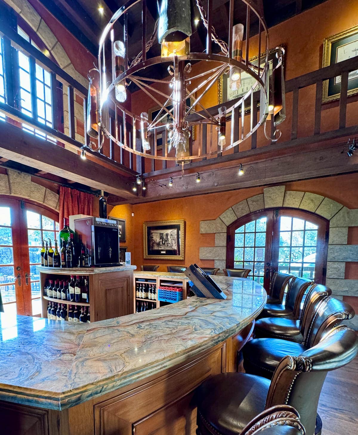 Wine tasting room with bar and leather chairs.