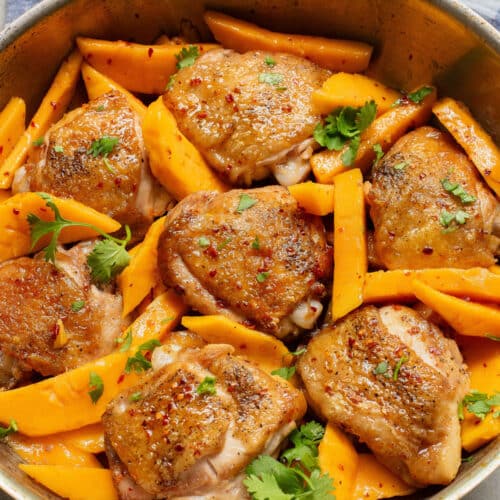 Chicken and mango slices in a pan.