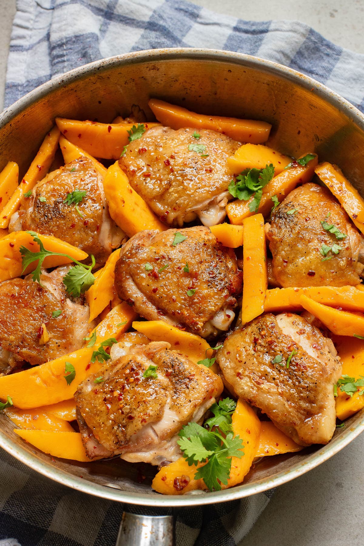 Chicken and mango slices in a pan.