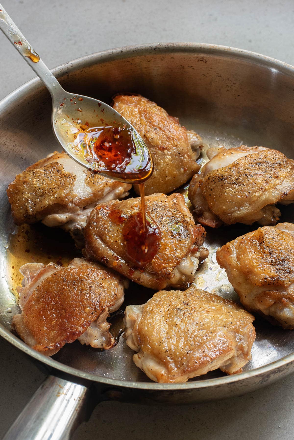 Chicken with sauce in a stainless pan.