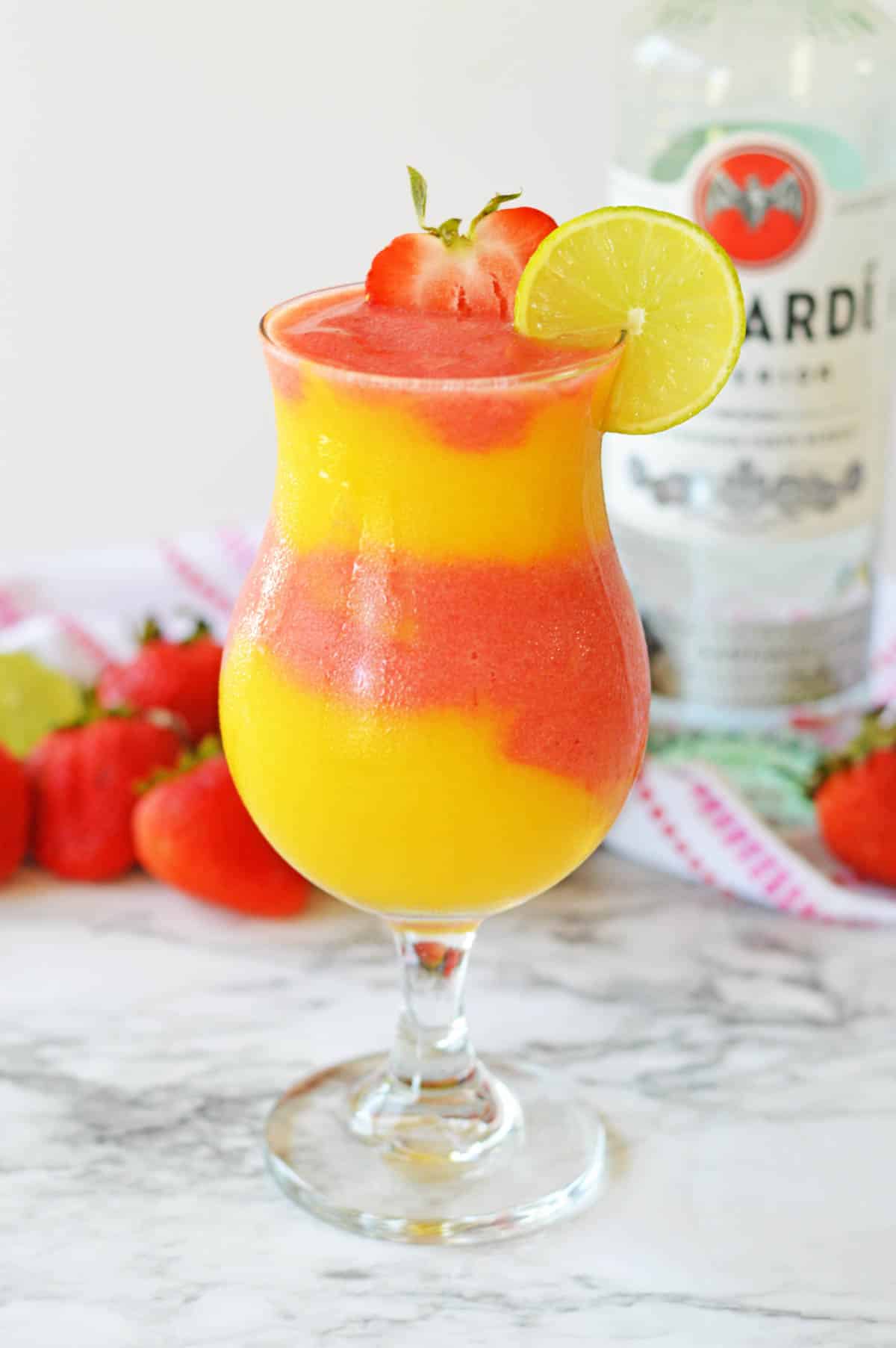 Strawberry and mango frozen daiquiri in a hurricane glass.