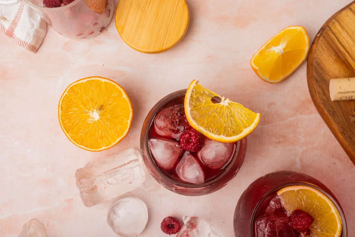 Wine and soda cocktail on plate of ice with orange slices.