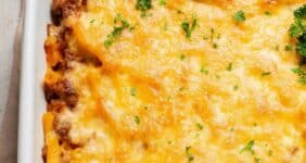 Baked ziti casserole topped with cheese and fresh parsley for Pinterest.