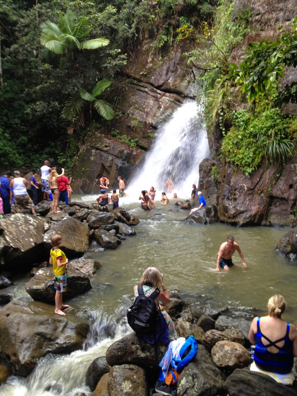Waterfall with people swimming.