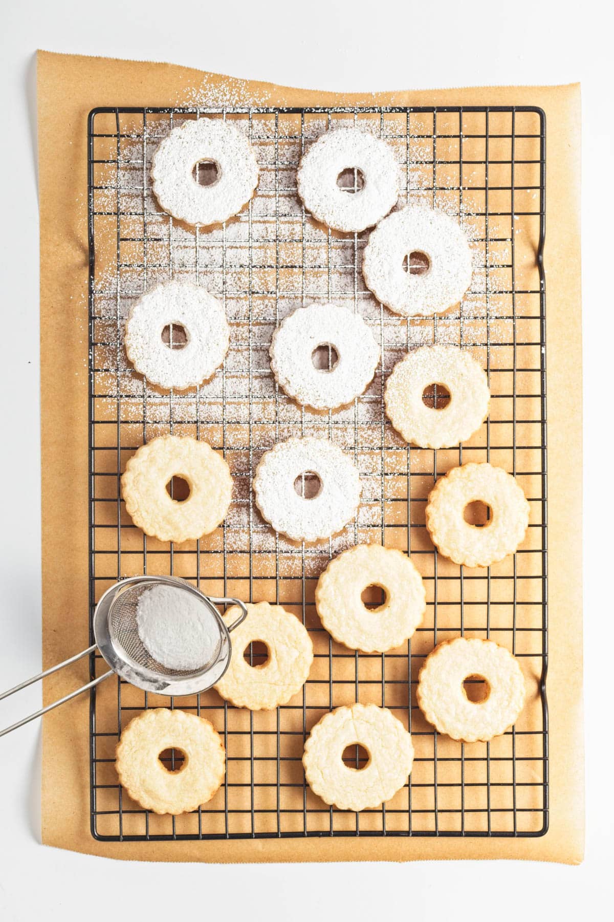 Cookies being sprinkled with powdered sugar.