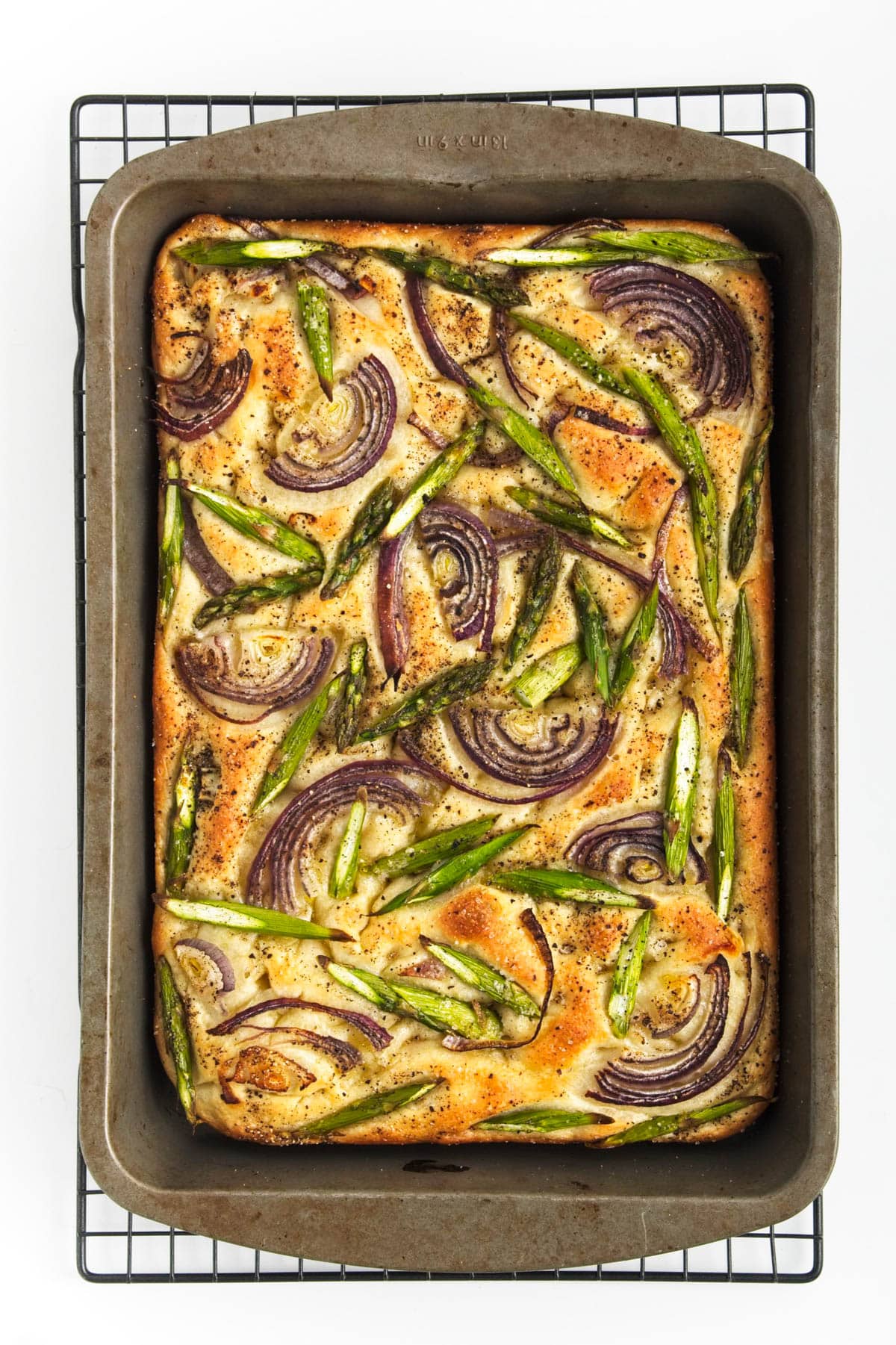 Baked bread with onion and asparagus in a baking pan.